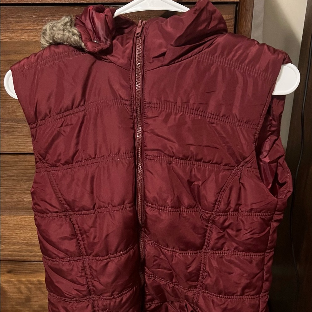 Zip up sleeveless jacket with pockets and hood.